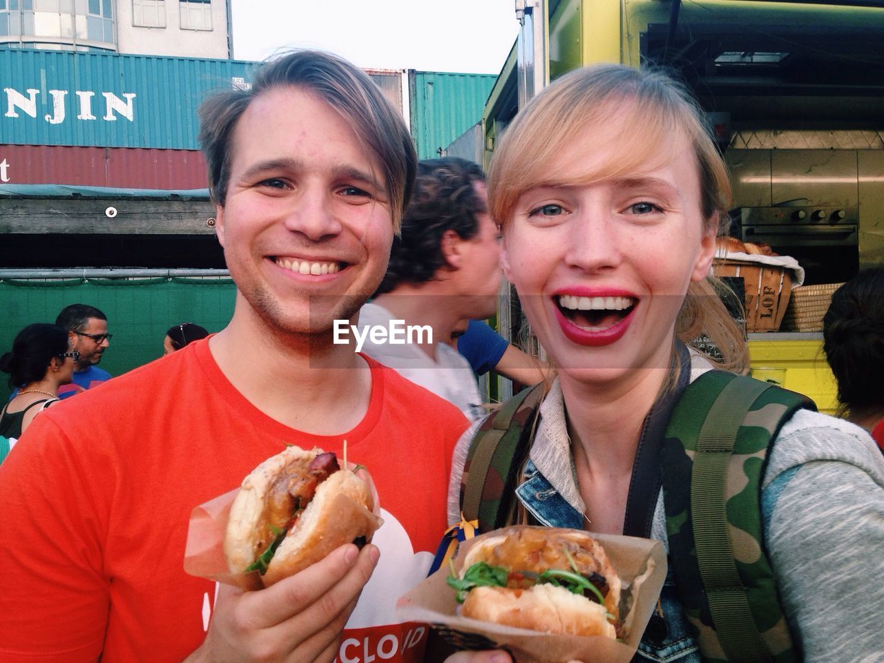 Smiling couple holding hamburgers