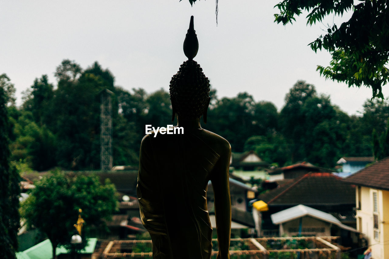 REAR VIEW OF MAN STATUE AT TEMPLE