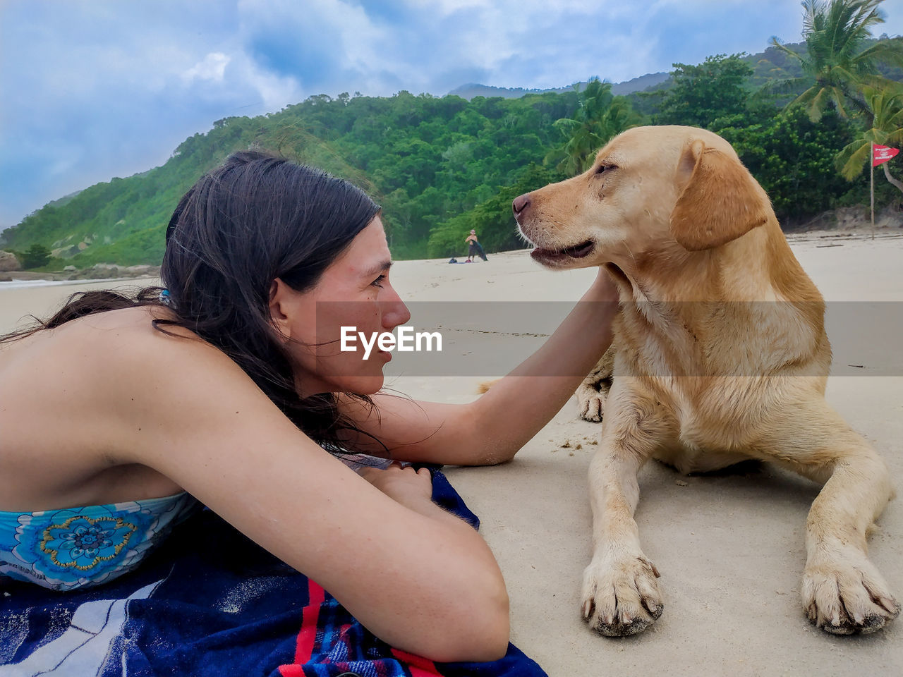 MIDSECTION OF WOMAN WITH DOG SITTING ON CAR