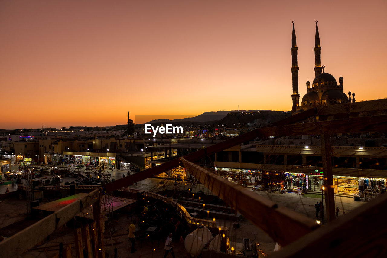 Panoramic top view of al sahab mosque and old town at sunset. silhouettes of people in shopping 