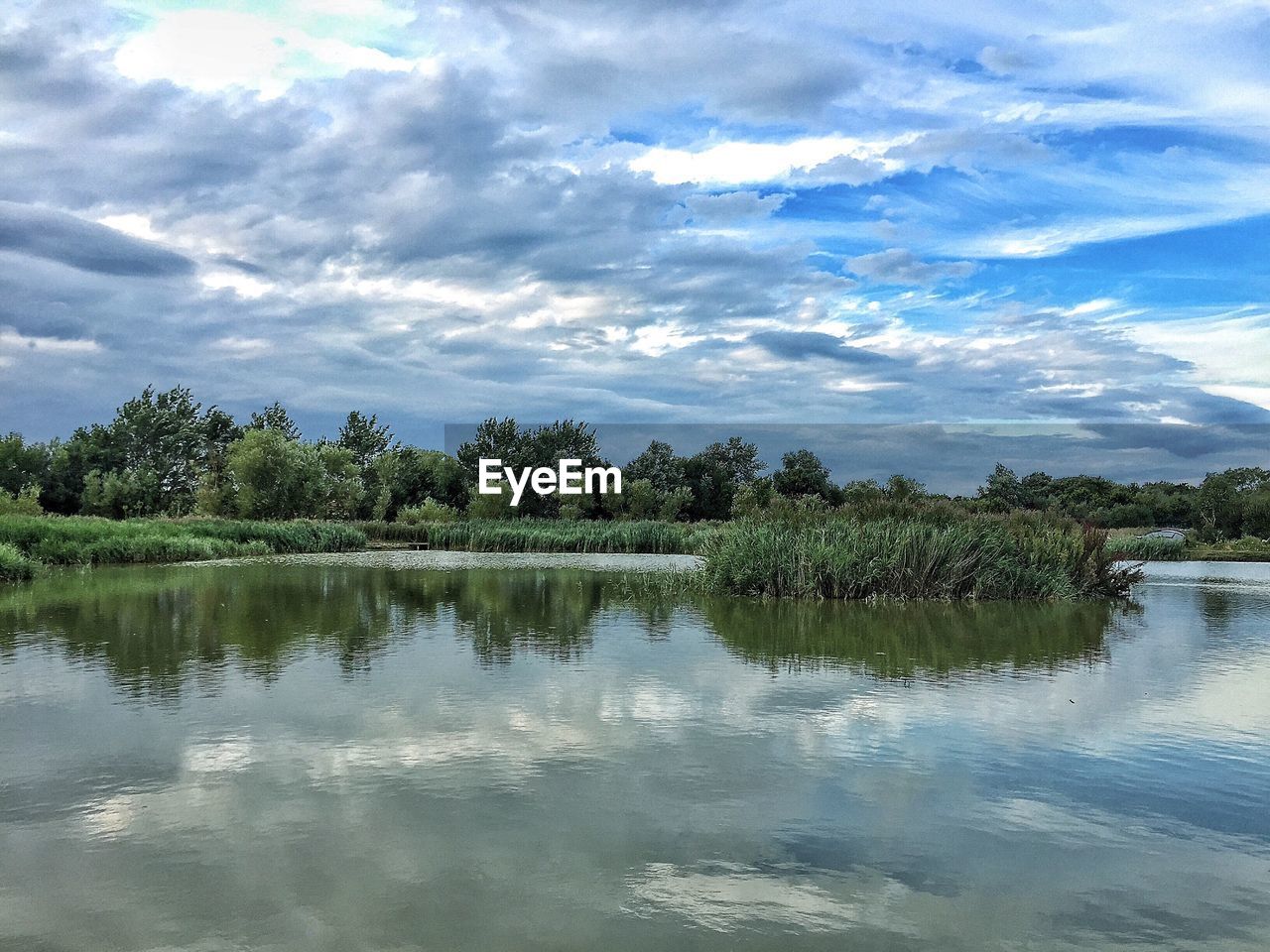 SCENIC VIEW OF LAKE AGAINST CLOUDY SKY