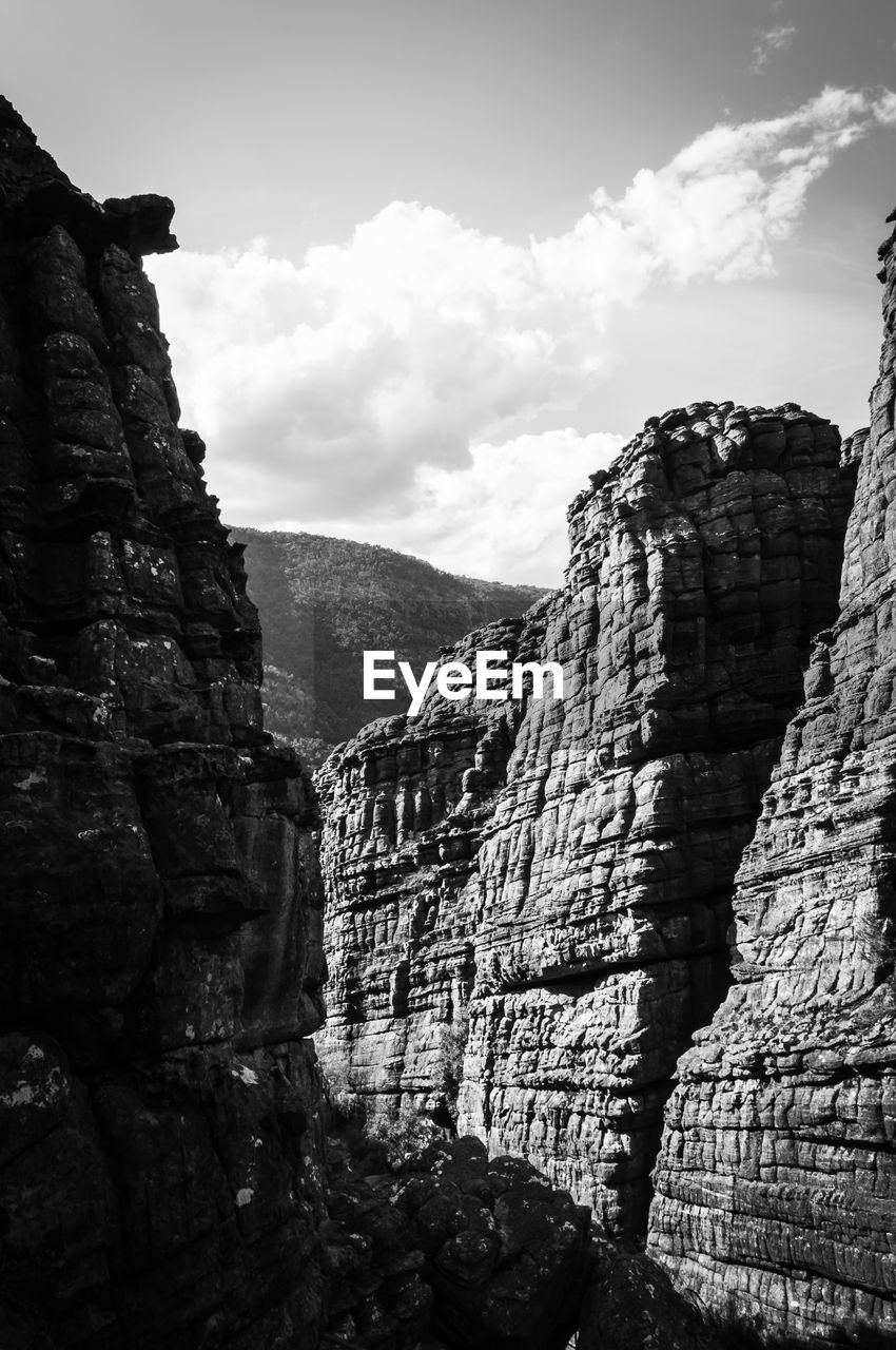 Rock formation on mountain against cloudy sky