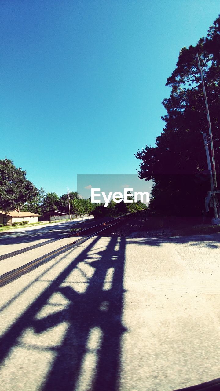 EMPTY ROAD WITH TREES IN BACKGROUND