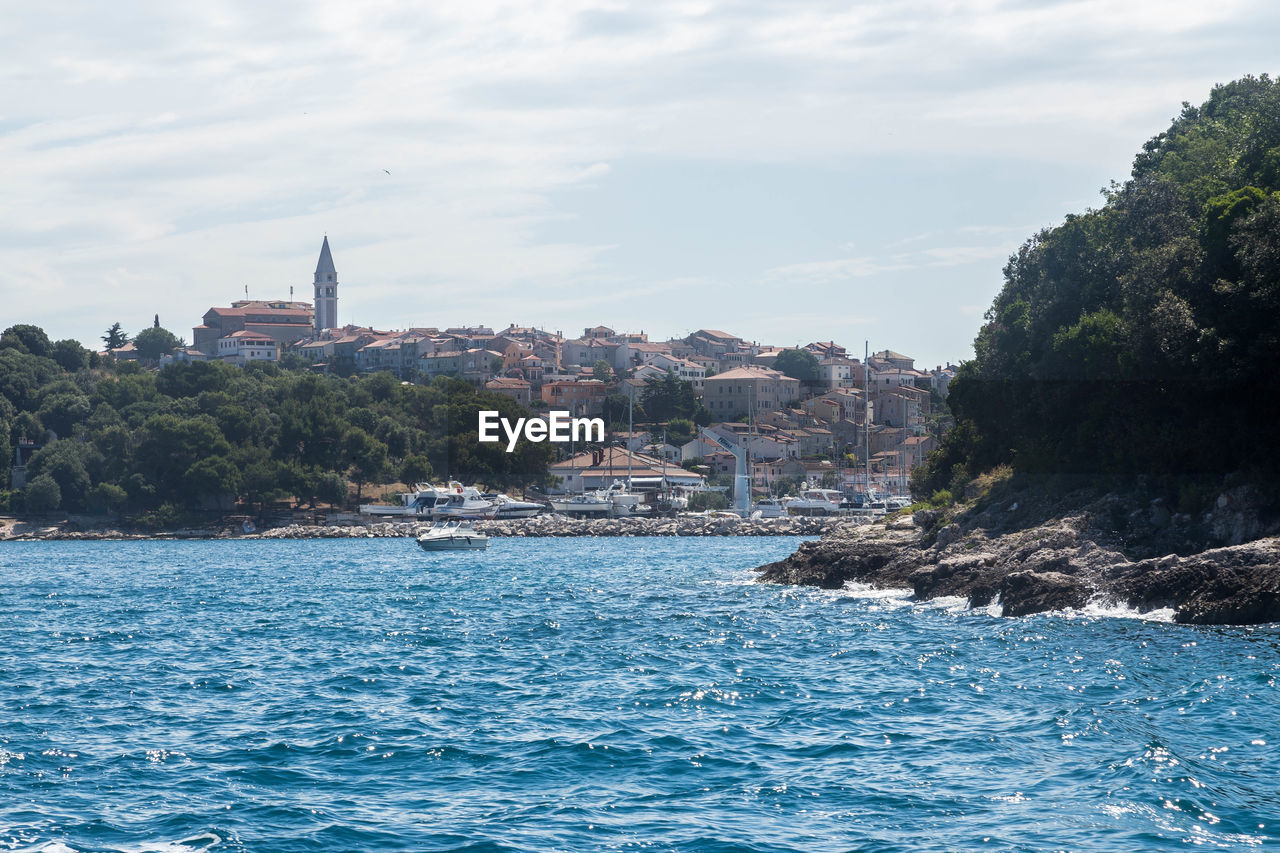 SEA AND BUILDINGS AGAINST SKY