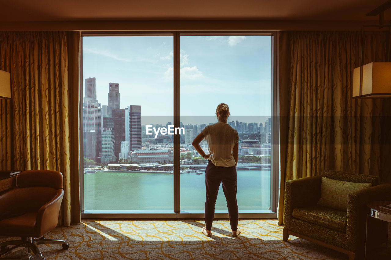 FULL LENGTH OF MAN STANDING BY WINDOW