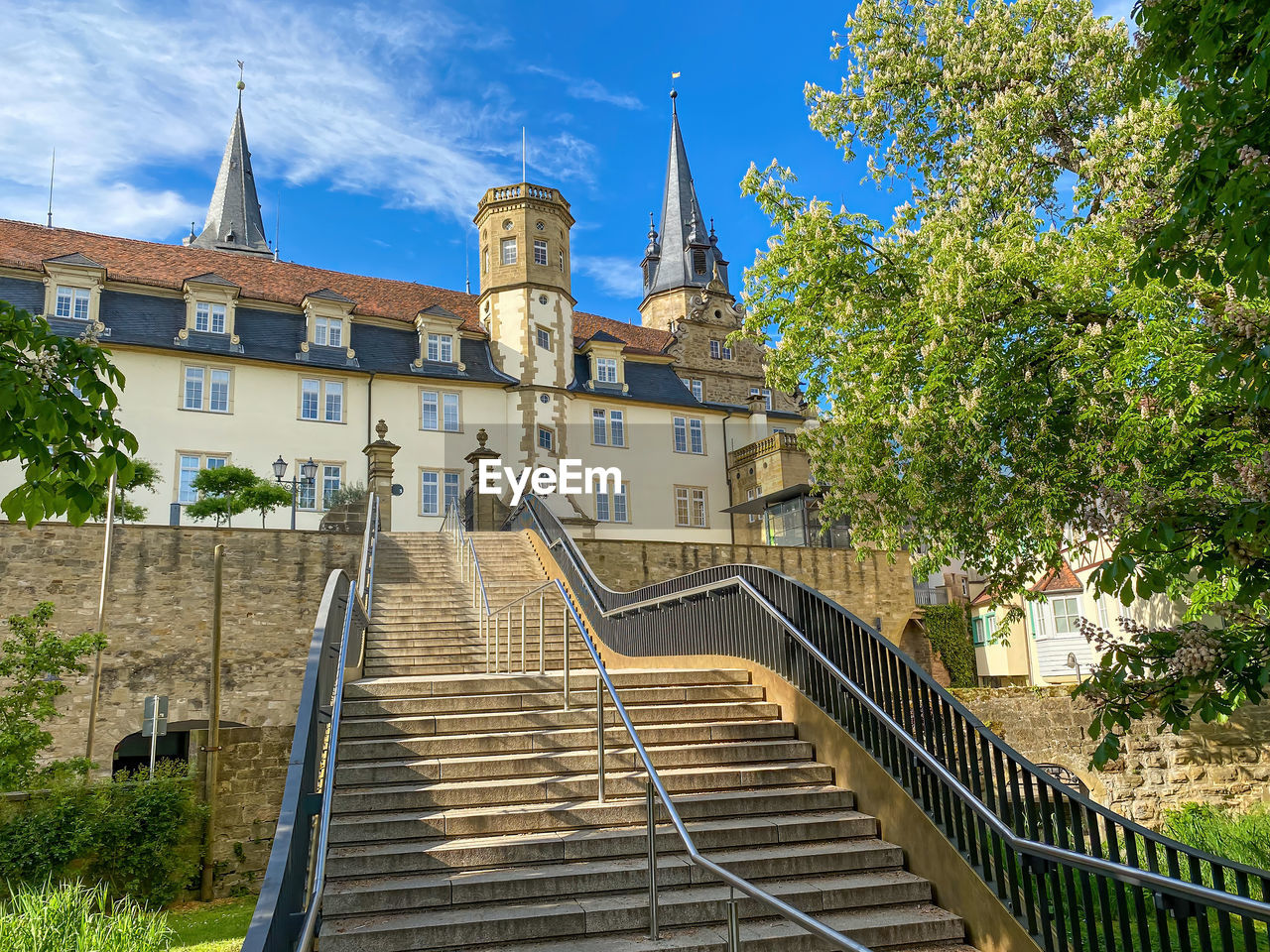 LOW ANGLE VIEW OF STAIRCASE AMIDST BUILDINGS AGAINST SKY