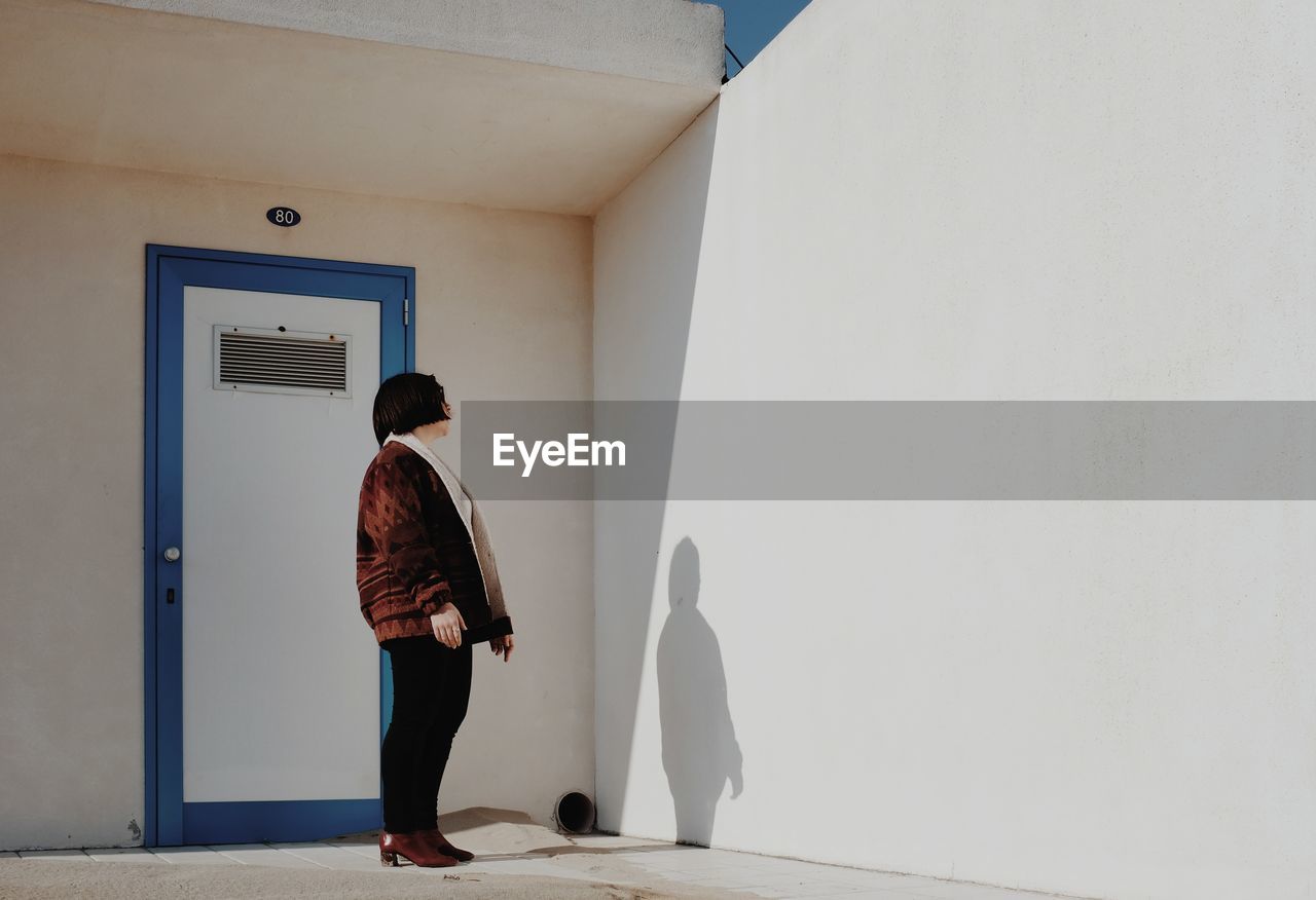 Woman standing against house