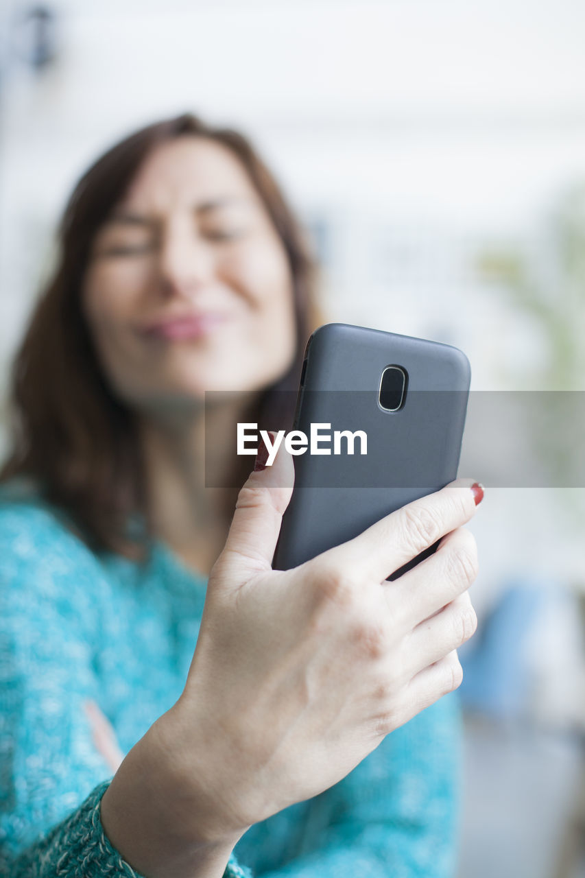 Close-up of woman taking selfie with mobile phone