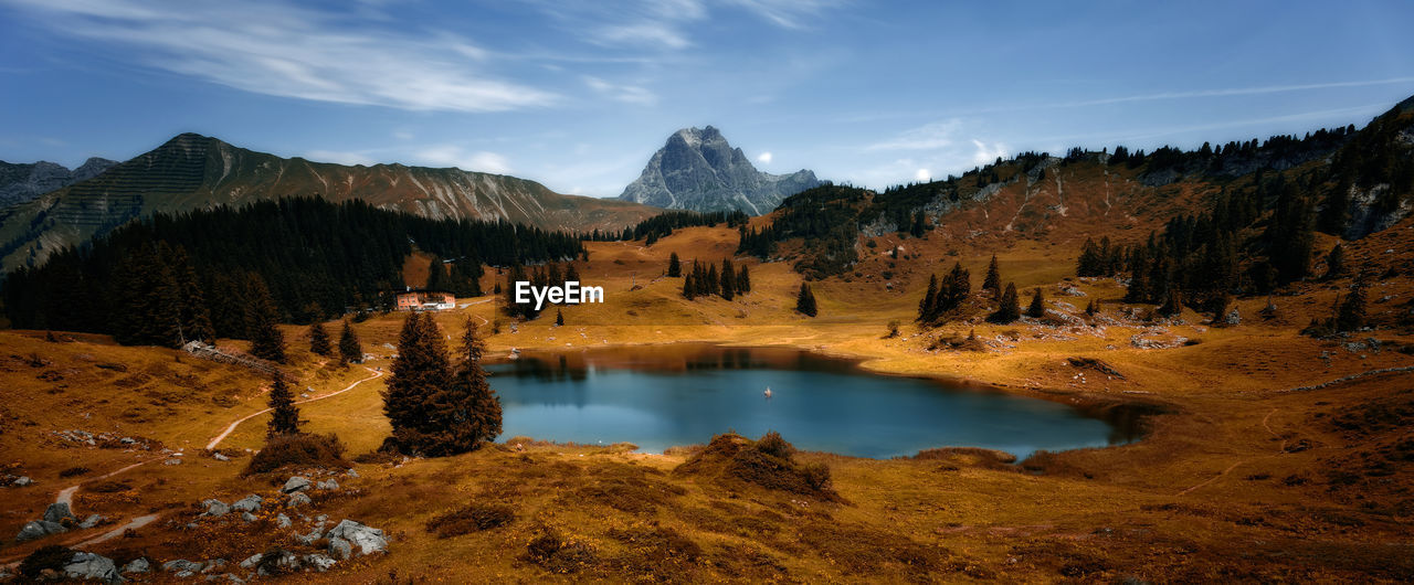 Scenic view of lake by mountains against sky