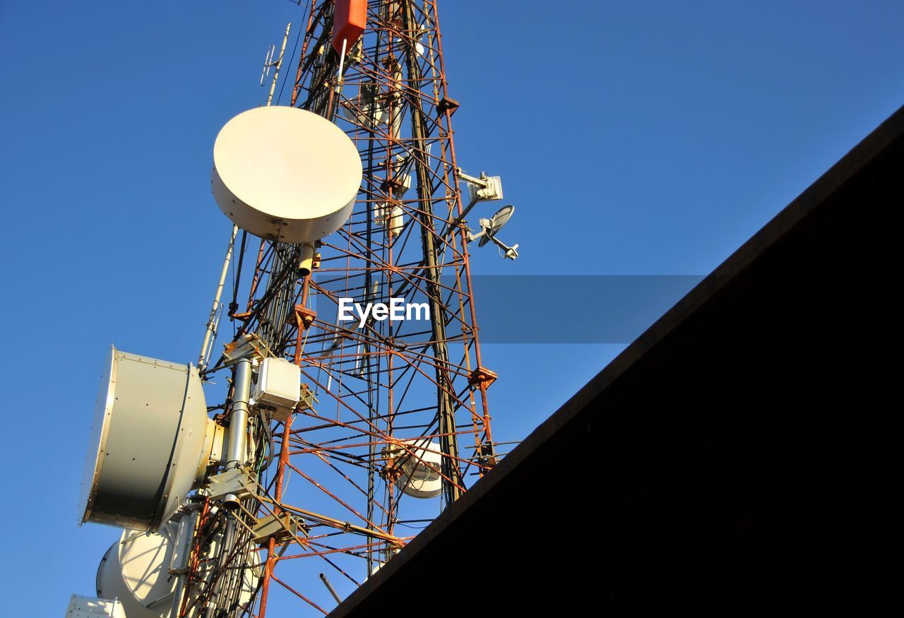 Low angle view of electricity pylon against clear sky