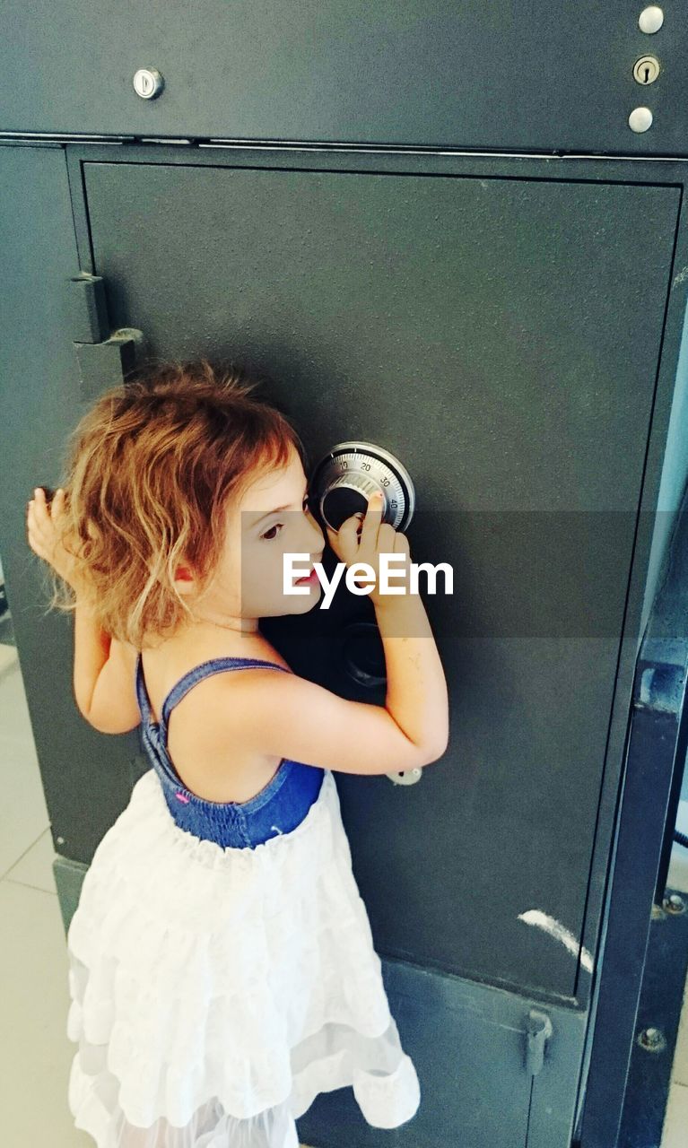 Cute girl in front of safety deposit box