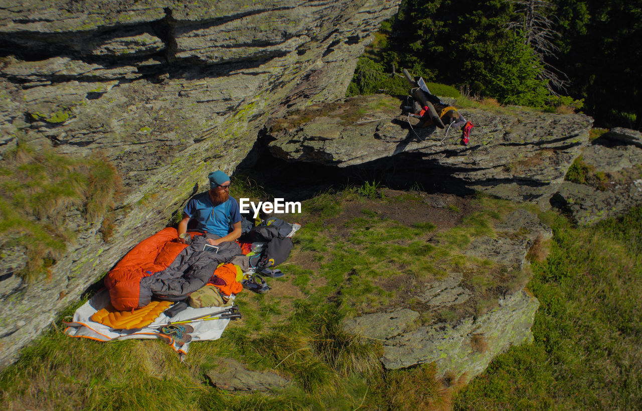 High angle view of man in sleeping bag by rock formations