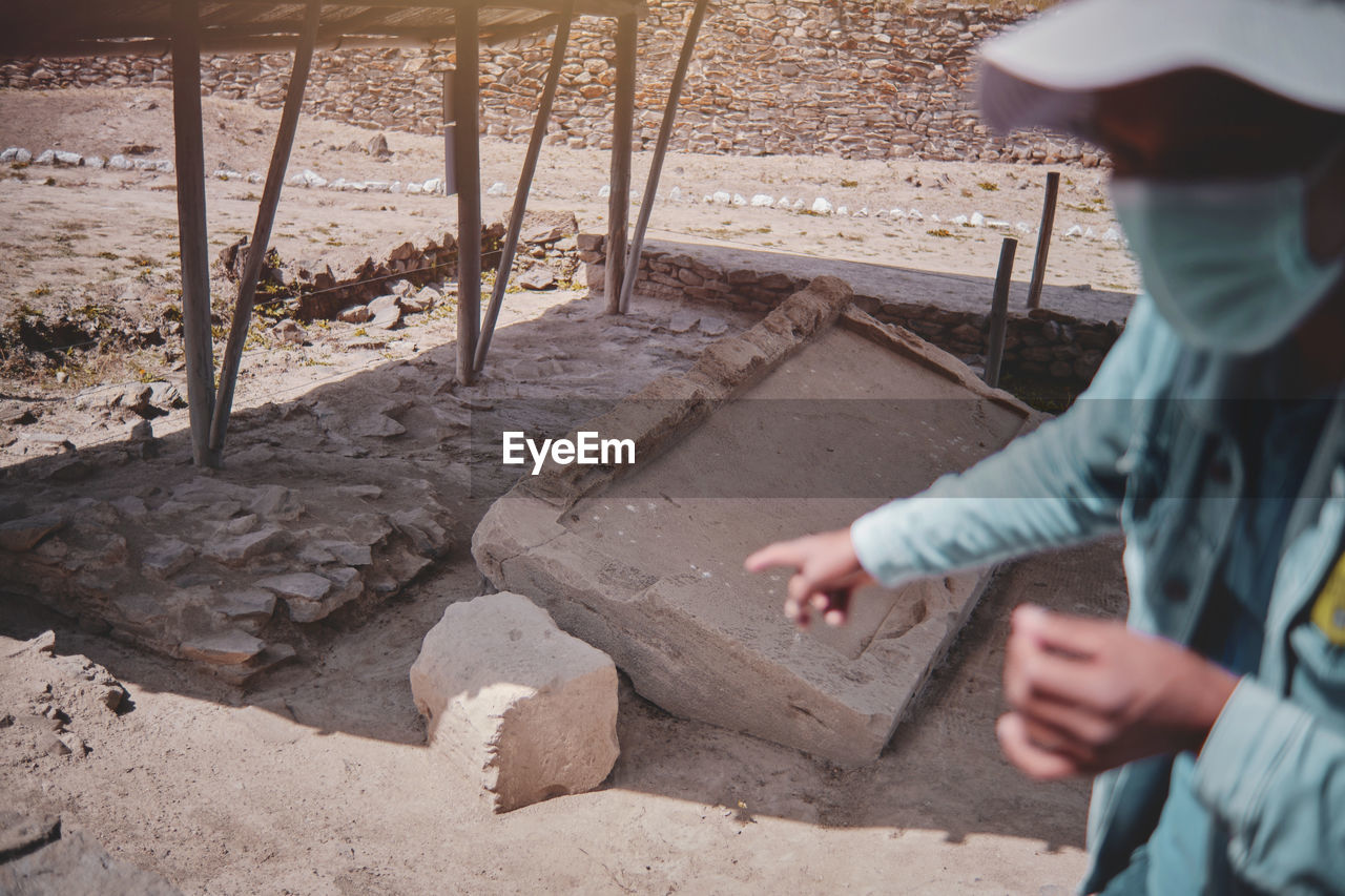 Group of tourists listening the guide explanation about wari archaeological complex, ayacucho. peru