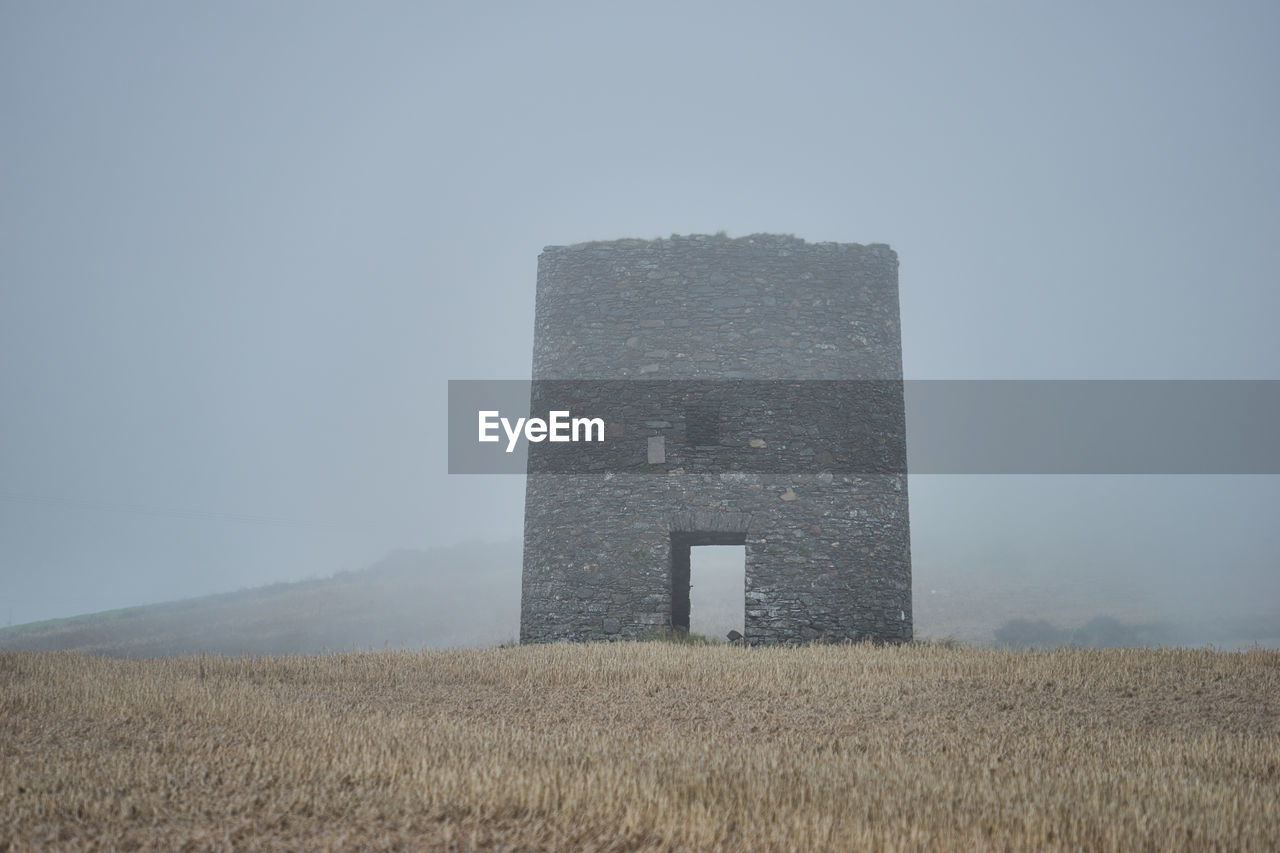 Barn on field against clear sky