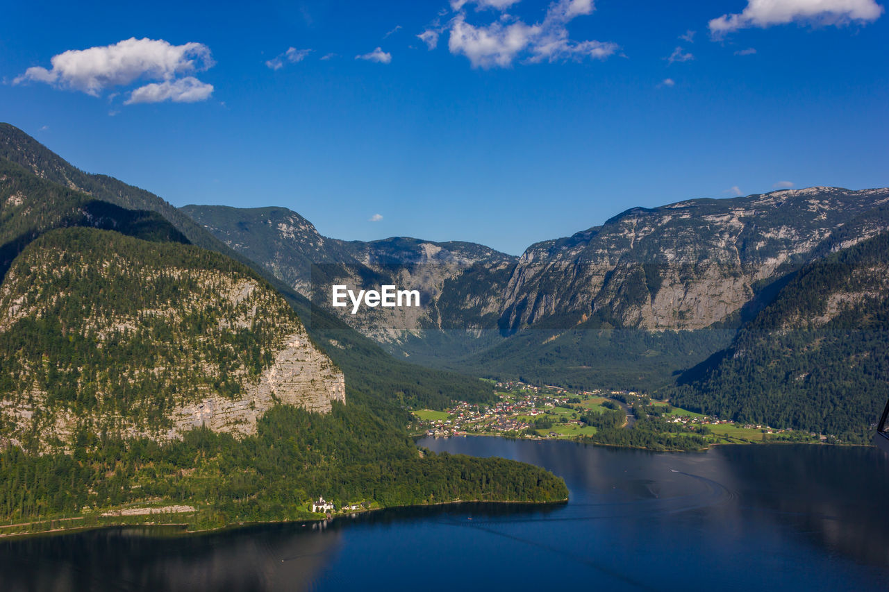 Scenic view of lake and mountains against blue sky