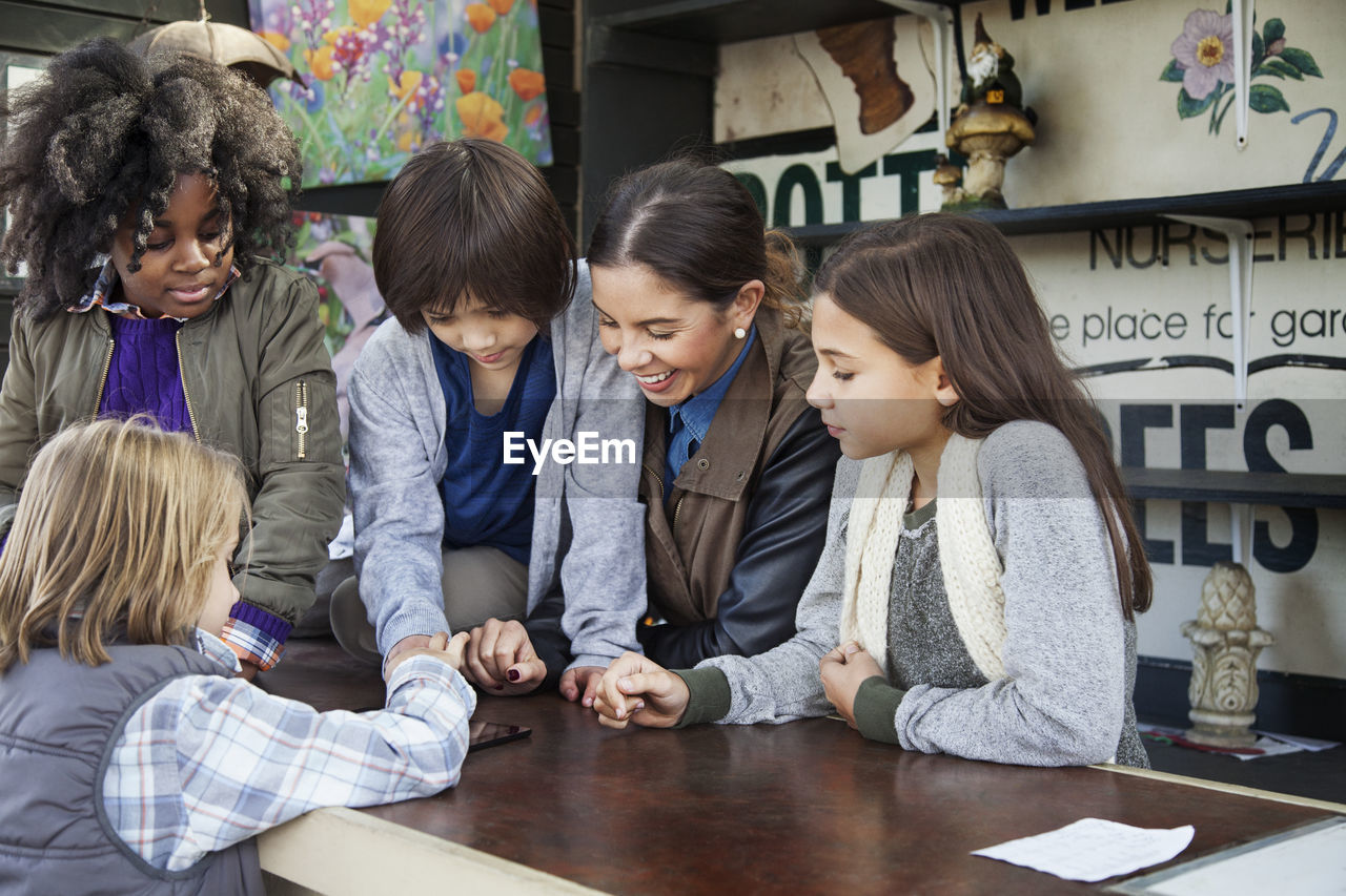 Students with teacher using tablet computer during field trip