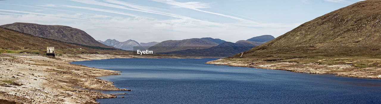 Scenic view of sea and mountains against sky