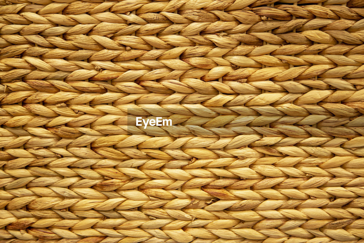 FULL FRAME SHOT OF WICKER BASKET ON STONE