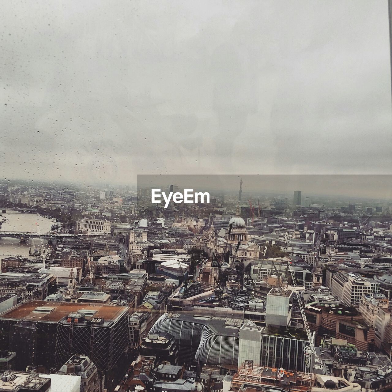 Cityscape against sky seen through glass window