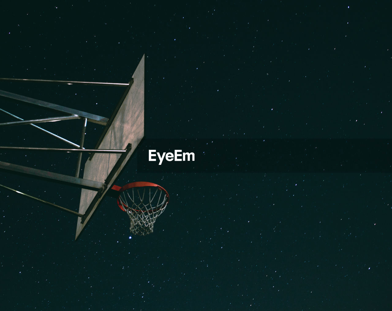 Low angle view of basketball hoop against sky at night