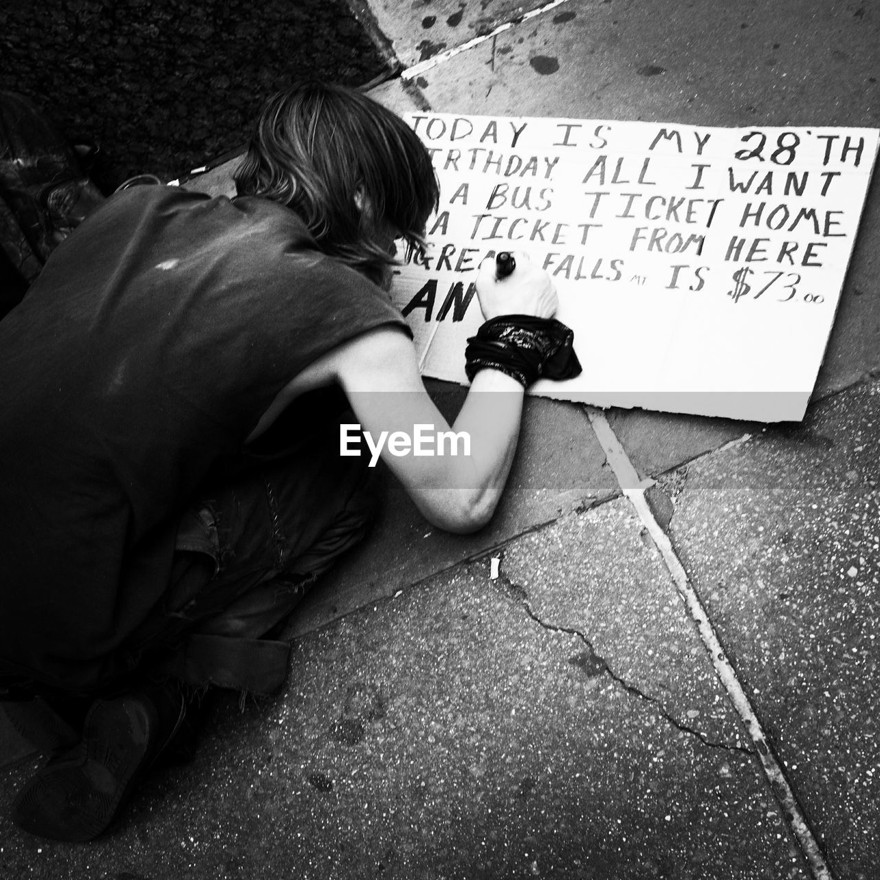 High angle view of homeless person making sign on street
