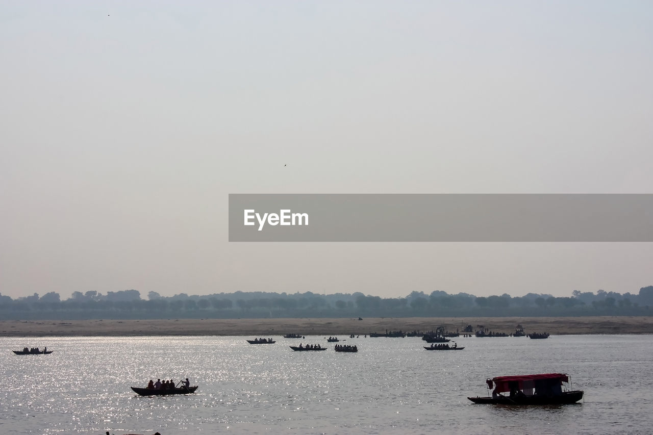 BOAT SAILING IN SEA AGAINST CLEAR SKY