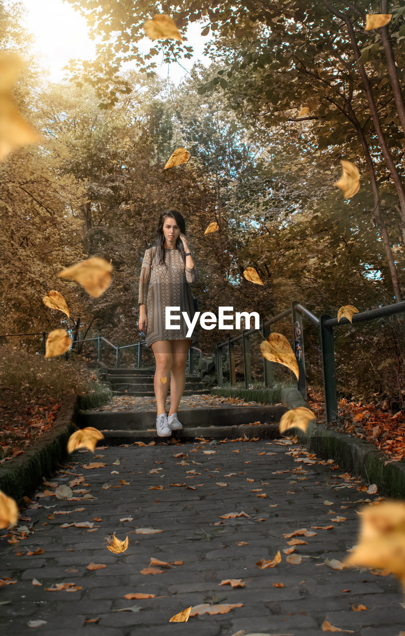 Full length of woman standing in park during autumn