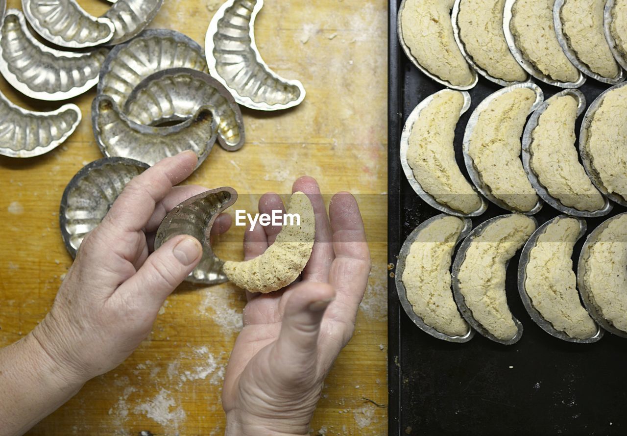 HIGH ANGLE VIEW OF WOMAN PREPARING FOOD AT TABLE