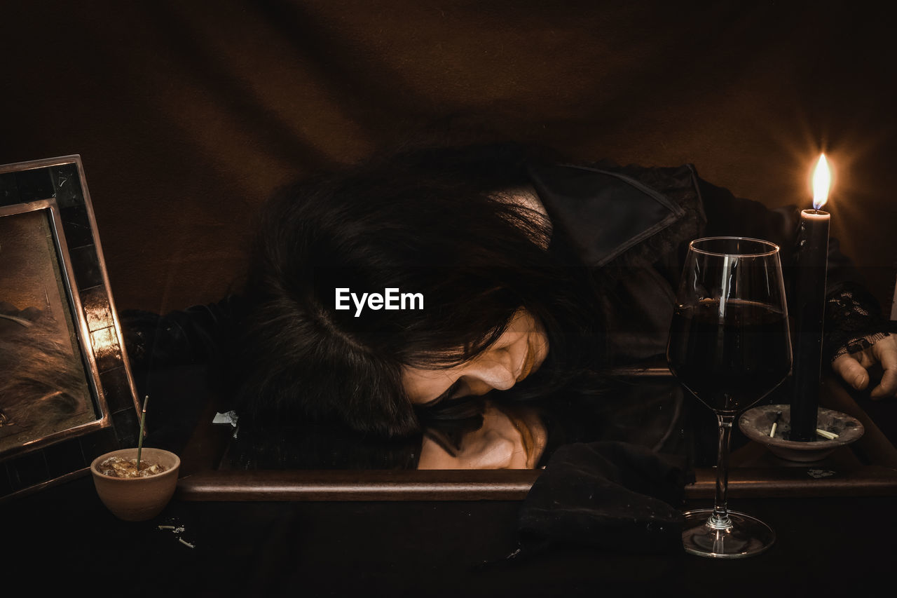 Woman drinking wine on table during wiccan ritual 