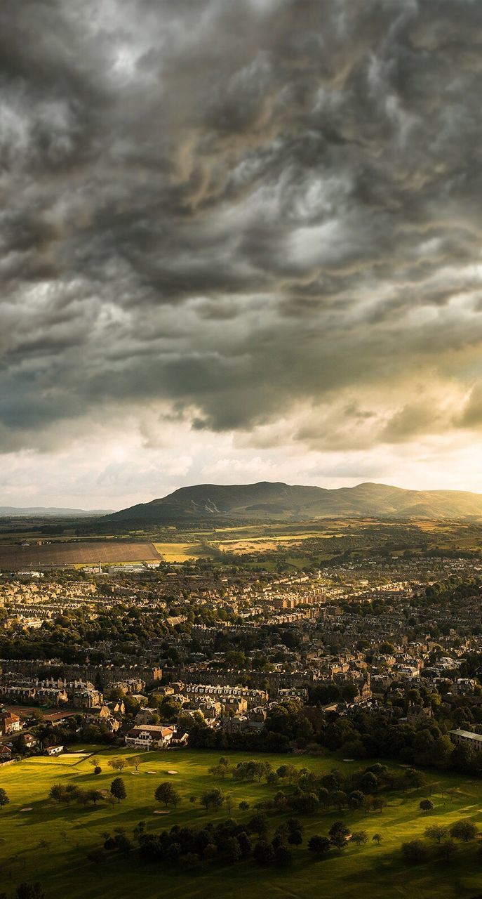 Scenic view of cityscape against cloudy sky