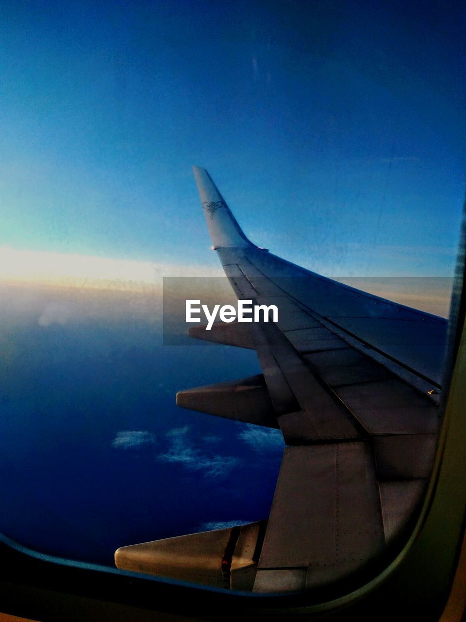 LOW ANGLE VIEW OF AIRPLANE WING OVER SEA