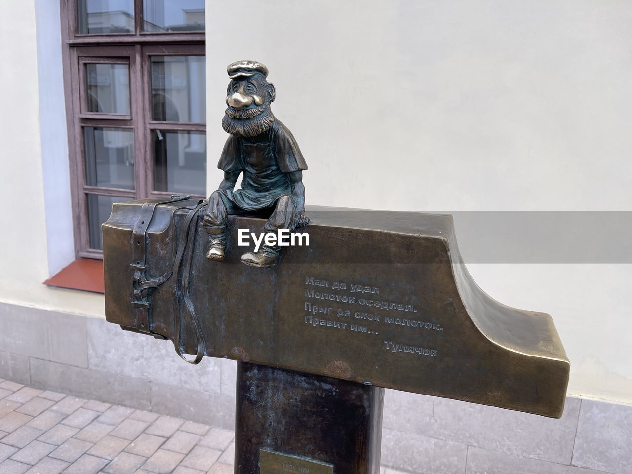 LOW ANGLE VIEW OF STATUE AGAINST METAL WINDOW