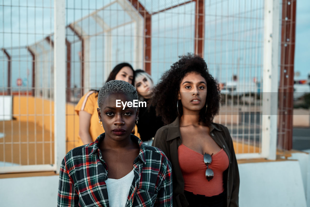 Ethnic young women in casual clothes looking at camera with fearless eyes