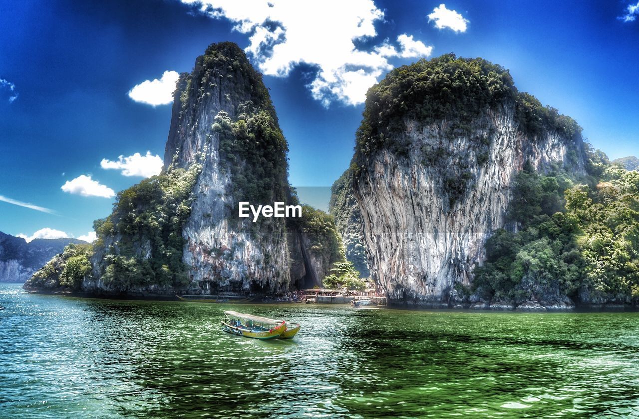 PANORAMIC VIEW OF TREES BY WATER AGAINST SKY