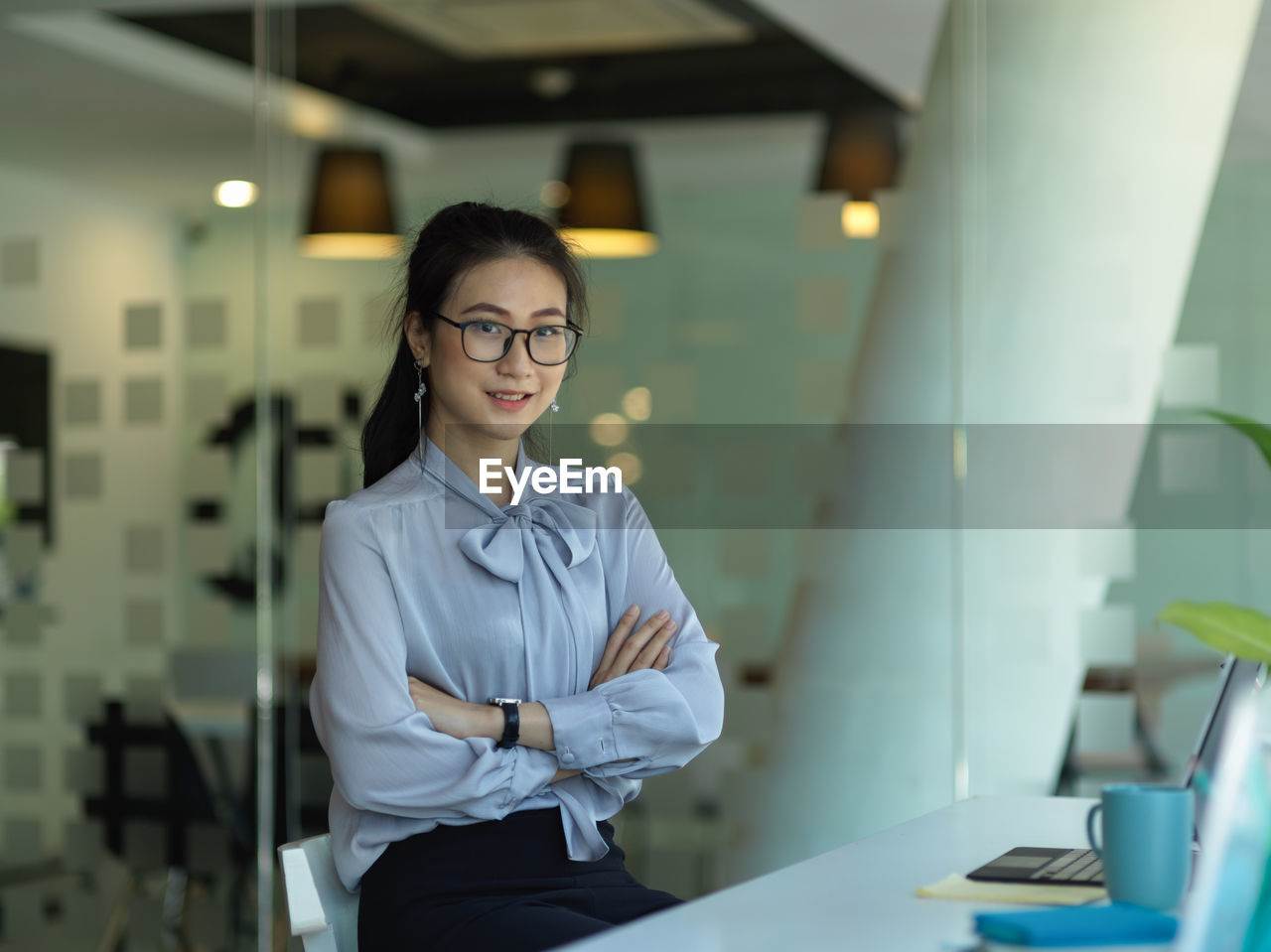 Portrait of smiling young woman sitting in office