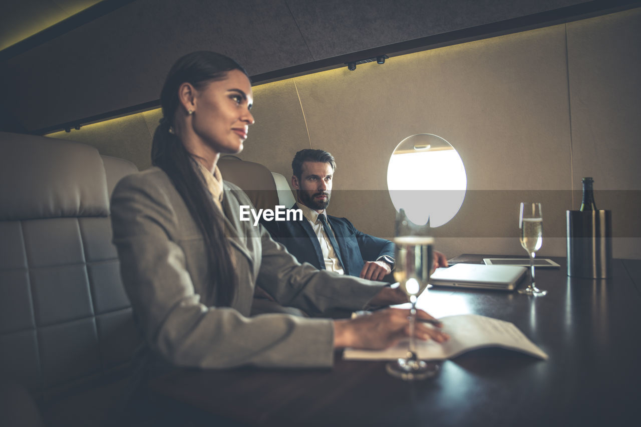 Business people sitting at table in airplane