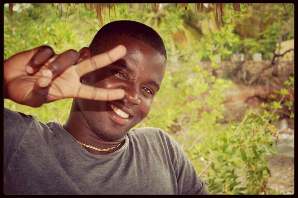 Smiling man showing peace sign