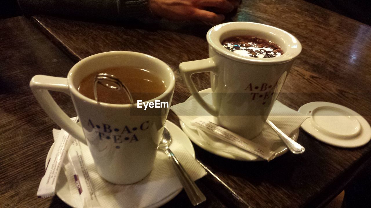 CLOSE-UP OF COFFEE CUP AND CUPS ON TABLE