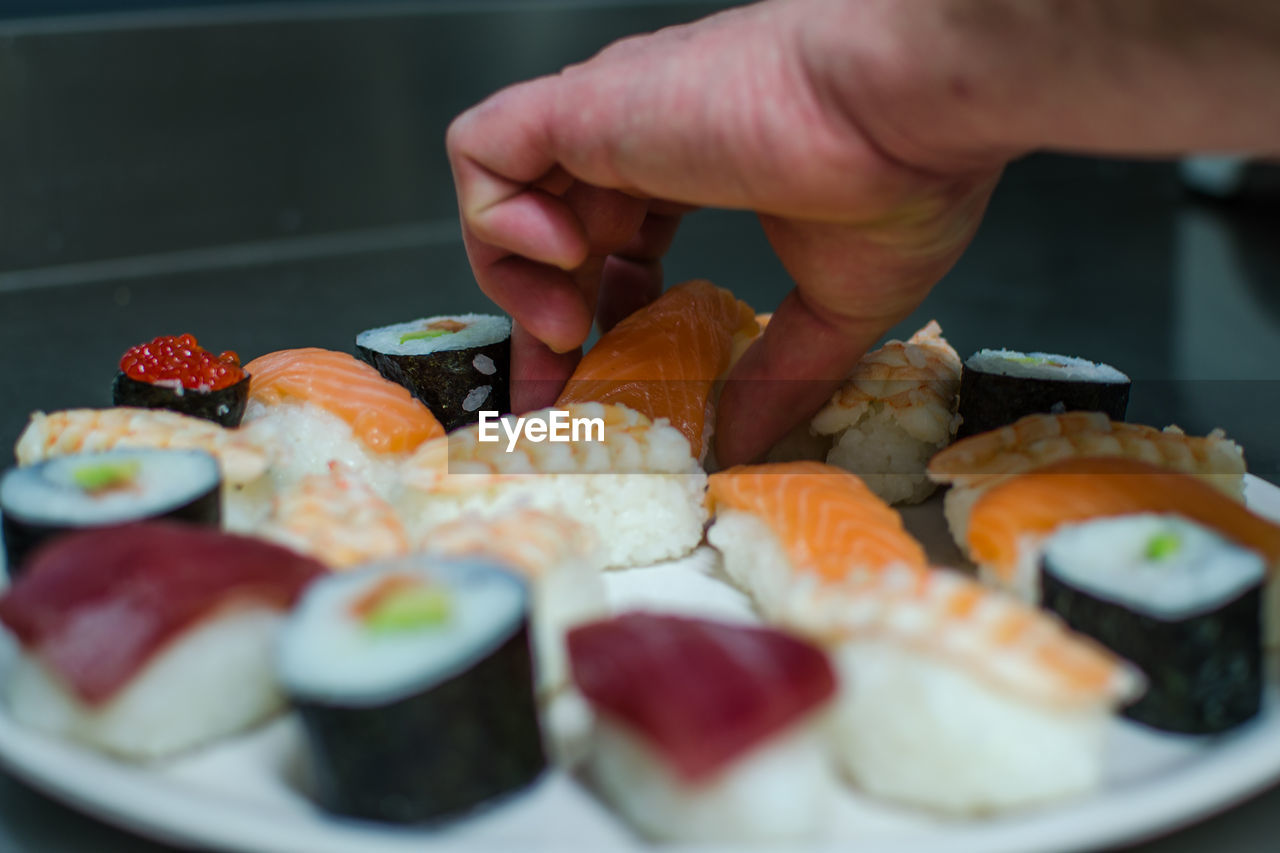 Cropped image of person preparing sushi