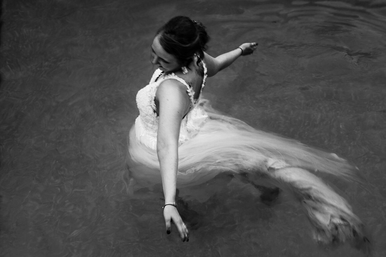 HIGH ANGLE VIEW OF WOMAN SWIMMING IN POOL