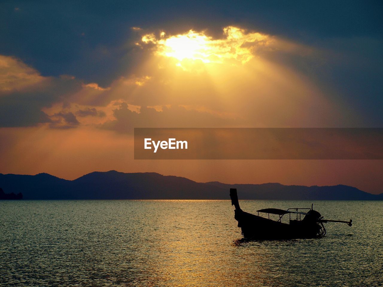 Silhouette boat in lake against sky during sunset