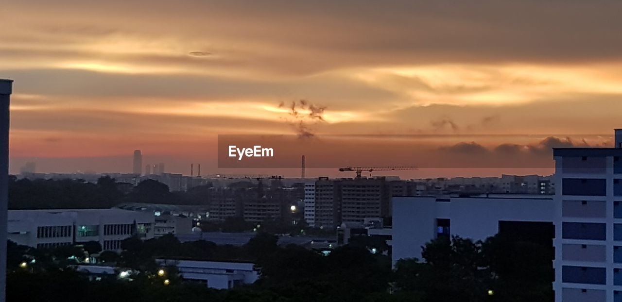 HIGH ANGLE VIEW OF BUILDINGS AGAINST SKY DURING SUNSET