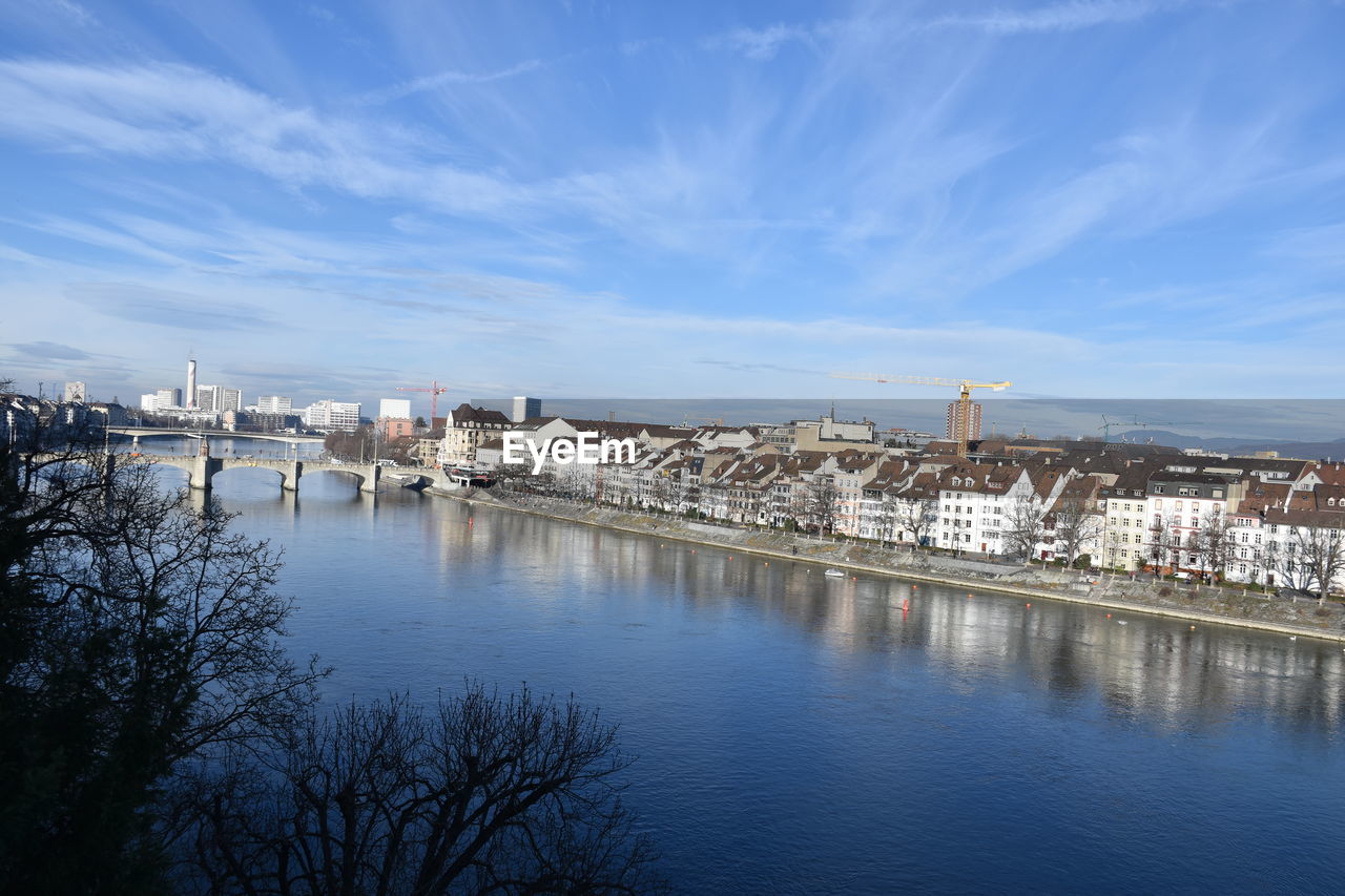 A scenic view of river by buildings against sky. winter without snow in 2020