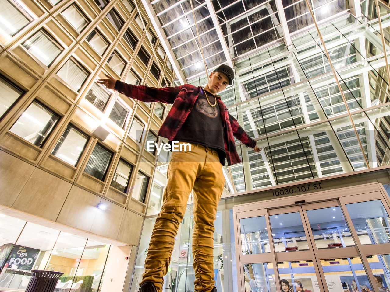LOW ANGLE VIEW OF MAN WITH UMBRELLA STANDING IN OFFICE BUILDING