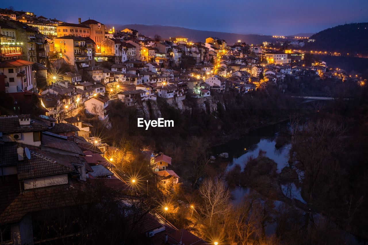 Illuminated cityscape against sky at night