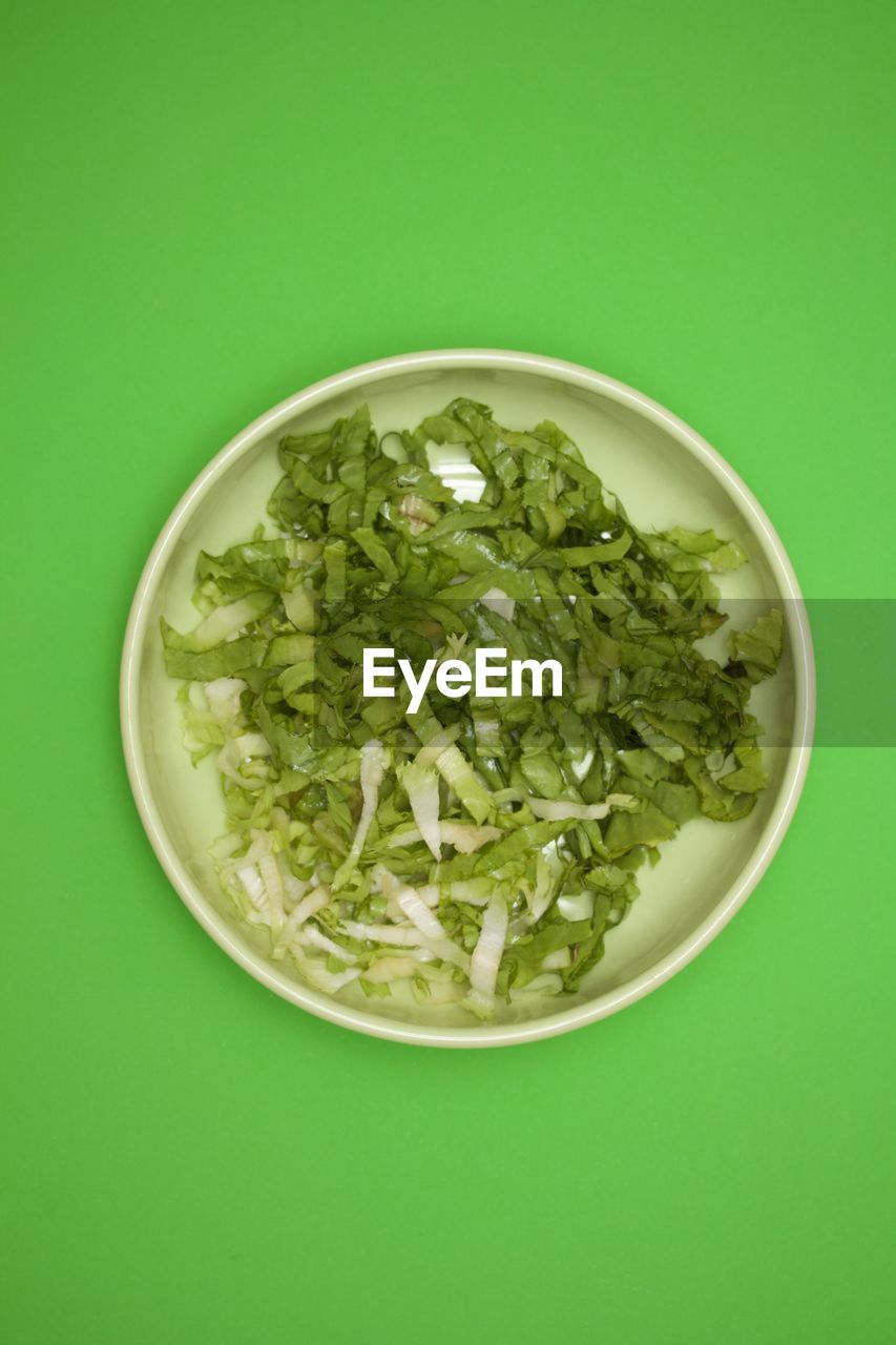 HIGH ANGLE VIEW OF SALAD IN BOWL AGAINST GREEN BACKGROUND