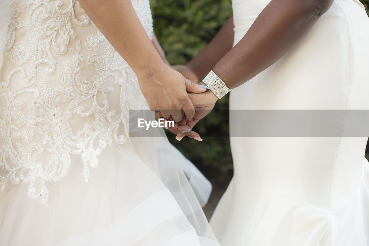 Midsection of couple holding hands