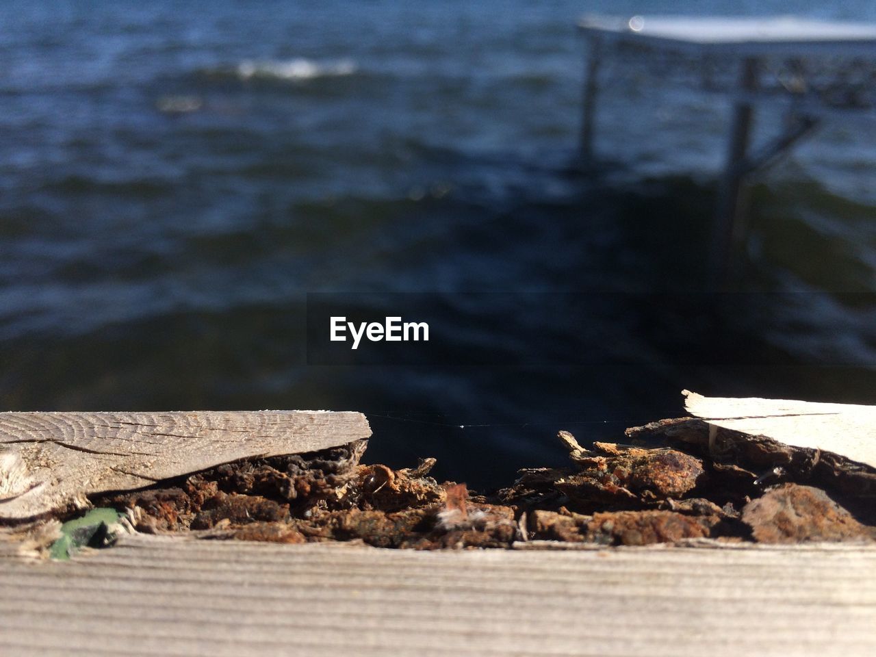 Cropped image of broken pier against sea