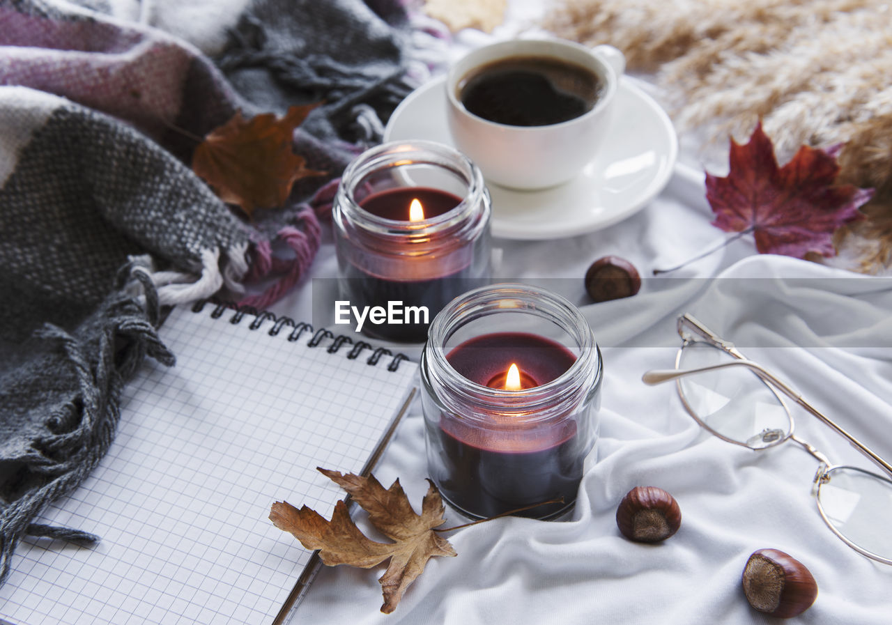 Autumn still life with pumpkins, coffee and burning candles. cozy fall composition