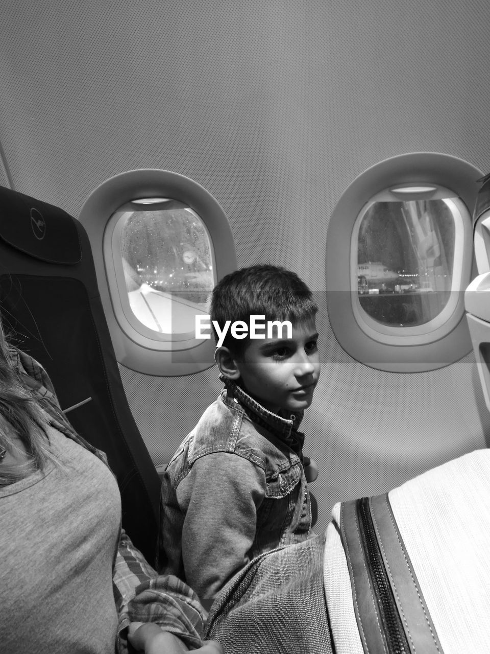 Boy sitting by window in airplane